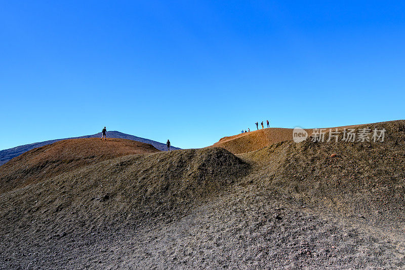 游客们在现存火山口凝固的熔岩场中间探索小火山口。Formica Leo, Piton de la Fournaise，留尼旺岛，法国，欧洲。